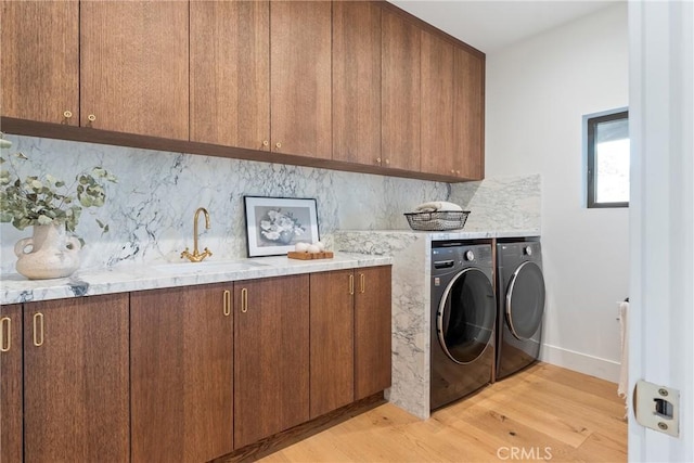 3250 Coldwater Canyon Ave, Studio City, CA 91604 - laundry room featuring cabinet space, washing machine and dryer, light wood finished floors, and baseboards
