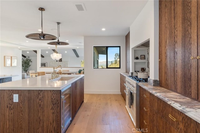 3250 Coldwater Canyon Ave, Studio City, CA 91604 - kitchen with stainless steel range, a sink, wine cooler, light wood-style floors, and modern cabinets