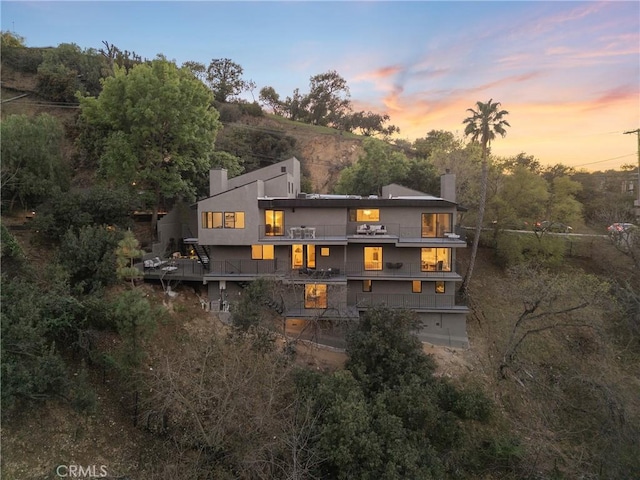 3250 Coldwater Canyon Ave, Studio City, CA 91604 - back of property at dusk with a balcony and a chimney