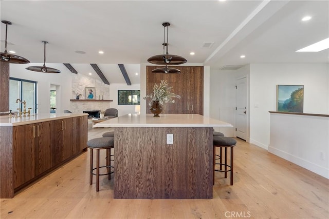 3250 Coldwater Canyon Ave, Studio City, CA 91604 - kitchen with a large island, light wood finished floors, a fireplace, a kitchen breakfast bar, and recessed lighting