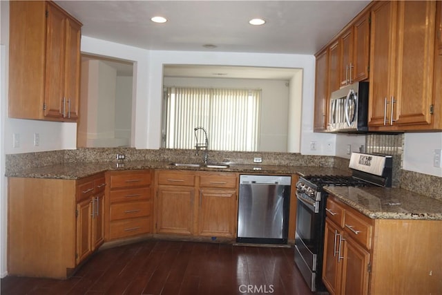 1044 Turner Ave Unit 207, Ontario, CA 91764 - kitchen with appliances with stainless steel finishes, a sink, dark stone countertops, dark wood-type flooring, and brown cabinets