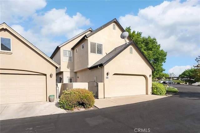 121 Wawona Pl, Chico, CA 95928 - view of front of house with driveway, an attached garage, stucco siding, and a gate