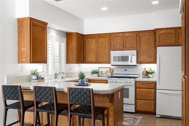 121 Wawona Pl, Chico, CA 95928 - kitchen with white appliances, a sink, a breakfast bar, a peninsula, and brown cabinets