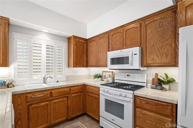 121 Wawona Pl, Chico, CA 95928 - kitchen featuring white appliances, a sink, brown cabinets, light tile patterned flooring, and tile countertops