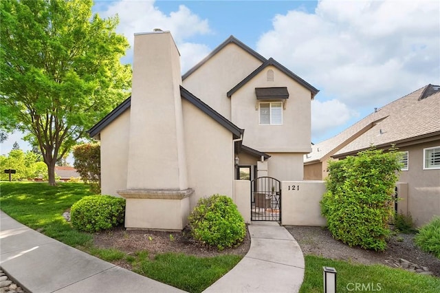 121 Wawona Pl, Chico, CA 95928 - view of front of home with a gate, stucco siding, and a front yard