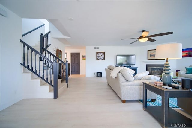 308 13th St, Seal Beach, CA 90740 - living room featuring stairway, light wood finished floors, a ceiling fan, and a glass covered fireplace