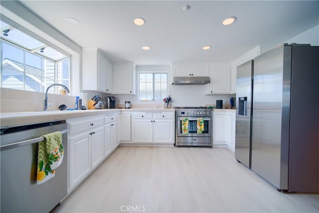308 13th St, Seal Beach, CA 90740 - kitchen with appliances with stainless steel finishes, under cabinet range hood, light wood finished floors, white cabinets, and recessed lighting