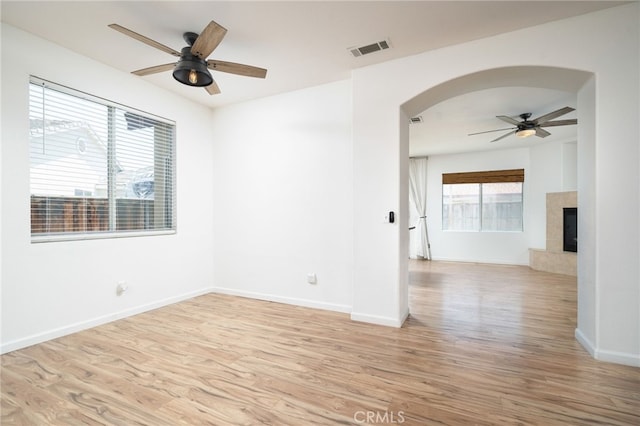 126 Schooner Ct, San Jacinto, CA 92583 - spare room featuring a ceiling fan, arched walkways, light wood-type flooring, and baseboards