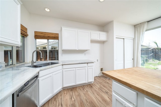 126 Schooner Ct, San Jacinto, CA 92583 - kitchen with stainless steel dishwasher, a sink, white cabinets, light wood-type flooring, and light stone countertops
