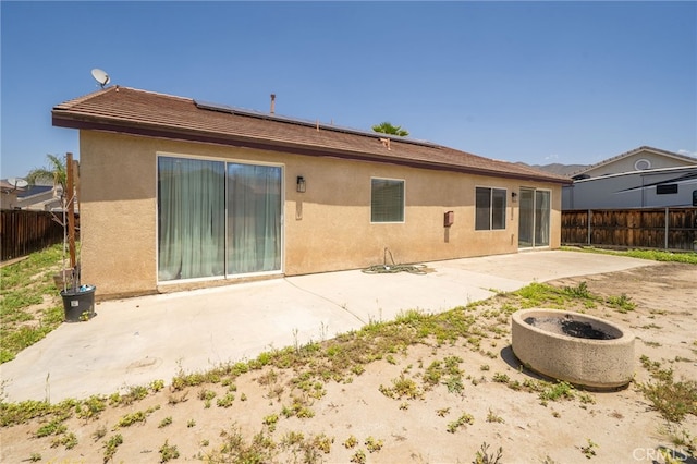 126 Schooner Ct, San Jacinto, CA 92583 - back of property featuring stucco siding, a patio, a fenced backyard, and solar panels