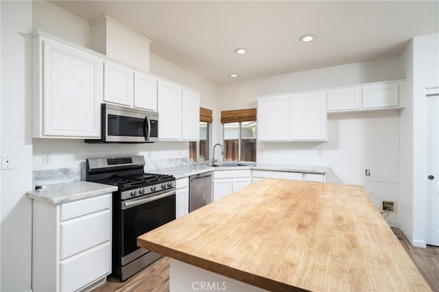 126 Schooner Ct, San Jacinto, CA 92583 - kitchen featuring stainless steel appliances, a sink, light wood finished floors, white cabinets, and recessed lighting