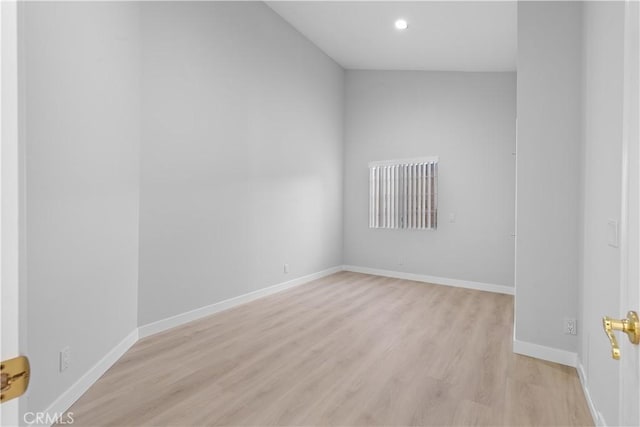 spare room with light wood-type flooring, baseboards, and recessed lighting