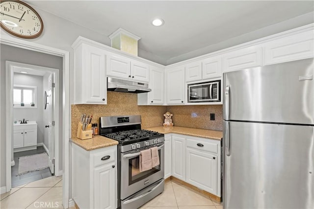 5136 W W Ave L8, Lancaster, CA 93536 - kitchen featuring appliances with stainless steel finishes, under cabinet range hood, light tile patterned floors, white cabinets, and recessed lighting