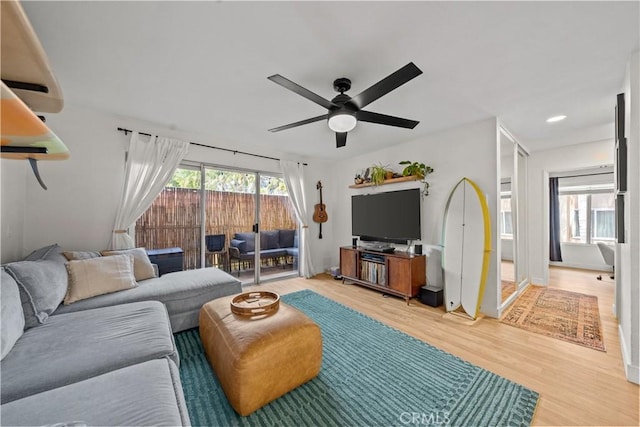living area featuring light wood-style floors, a ceiling fan, and recessed lighting