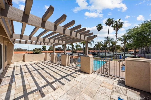 view of patio / terrace featuring a pergola, a community pool, and fence