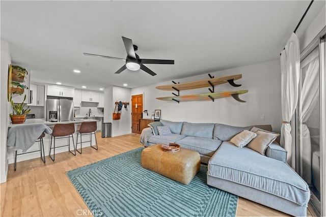 living area with ceiling fan, light wood finished floors, and recessed lighting