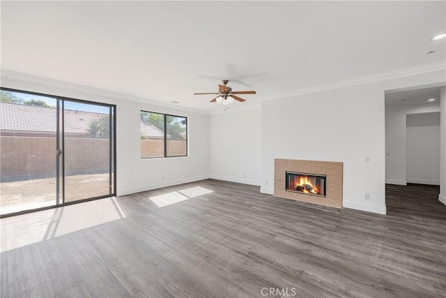 47432 Bahama Ct, Indio, CA 92201 - unfurnished living room featuring crown molding, baseboards, wood finished floors, a tiled fireplace, and a ceiling fan