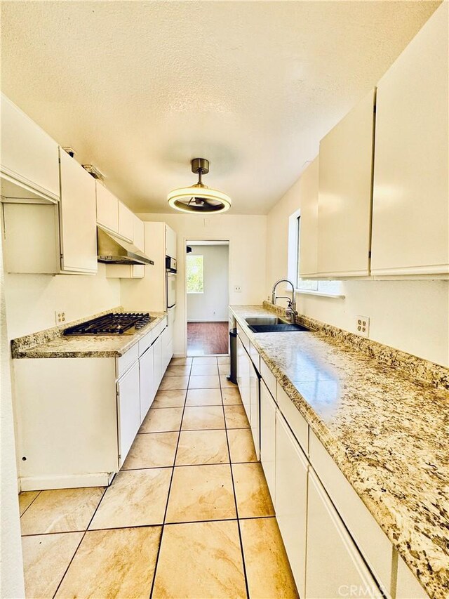7019 Chimineas Ave, Reseda, CA 91335 - kitchen with a sink, under cabinet range hood, stainless steel gas cooktop, oven, and light countertops