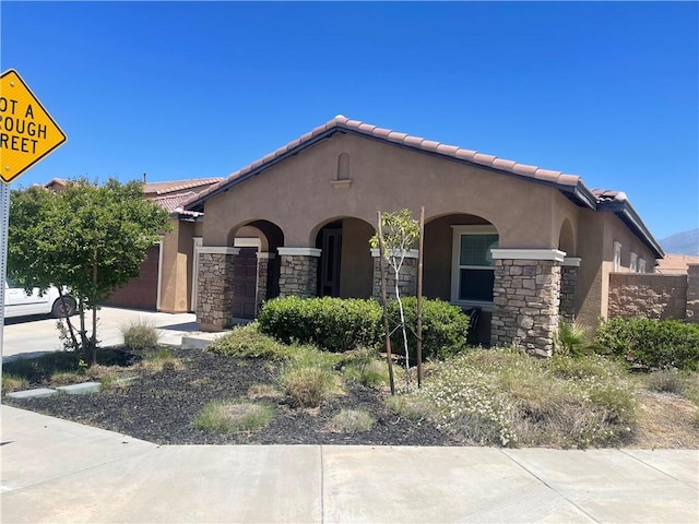 34988 Keiser Ct, Beaumont, CA 92223 - view of front of property featuring stucco siding, a tile roof, stone siding, and a garage