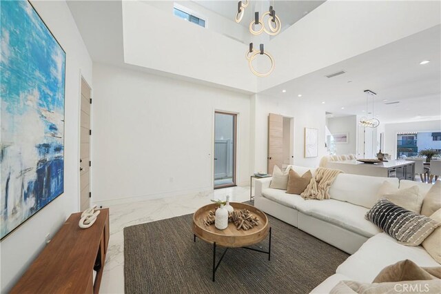 125 8th St, Huntington Beach, CA 92648 - living area with marble look tiles, a chandelier, recessed lighting, baseboards, and a towering ceiling