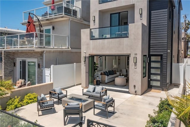 125 8th St, Huntington Beach, CA 92648 - rear view of house with an outdoor living space with a fire pit, a patio area, stucco siding, fence, and a balcony
