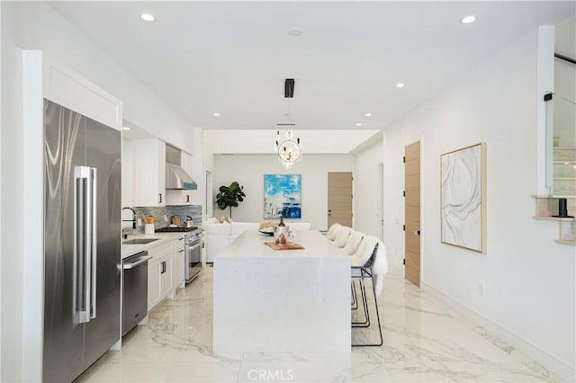 125 8th St, Huntington Beach, CA 92648 - kitchen with high end appliances, a sink, light marble finish flooring, a center island, and recessed lighting