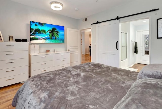 2230 Watermarke Pl, Irvine, CA 92612 - bedroom with a barn door and light wood-style floors
