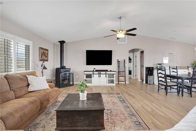 5824 White Fox Trl, Phelan, CA 92371 - living area with ceiling fan, wood finished floors, arched walkways, lofted ceiling, and a wood stove