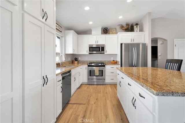 5824 White Fox Trl, Phelan, CA 92371 - kitchen featuring stainless steel appliances, a sink, light wood-style flooring, light stone counters, and a kitchen island