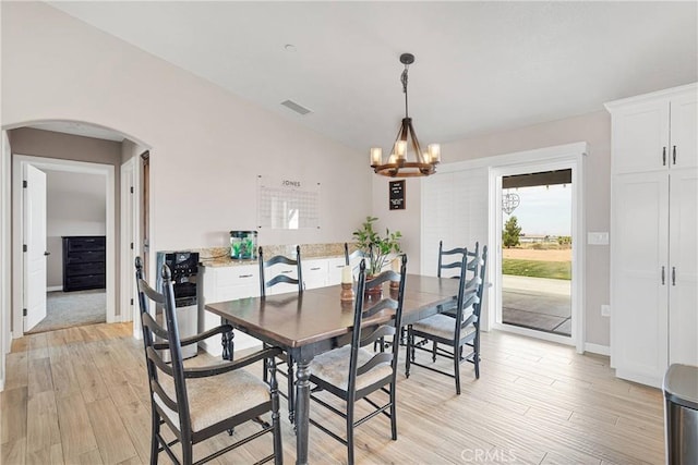 5824 White Fox Trl, Phelan, CA 92371 - dining room featuring arched walkways, a chandelier, light wood-style flooring, baseboards, and lofted ceiling