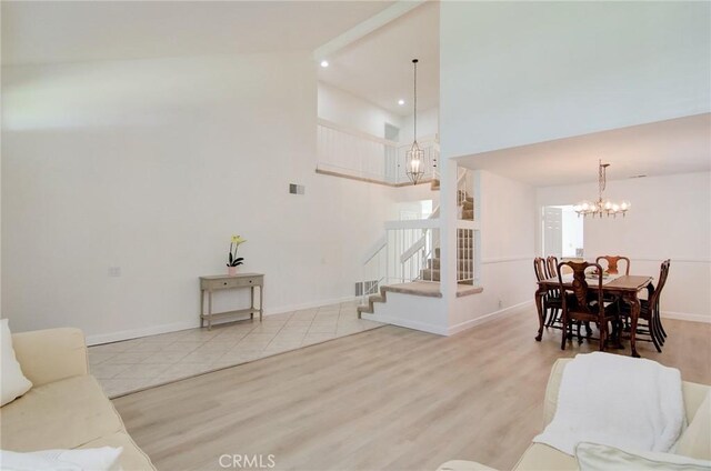22492 Eloise Dr, Lake Forest, CA 92630 - living area featuring a chandelier, high vaulted ceiling, stairs, wood finished floors, and baseboards