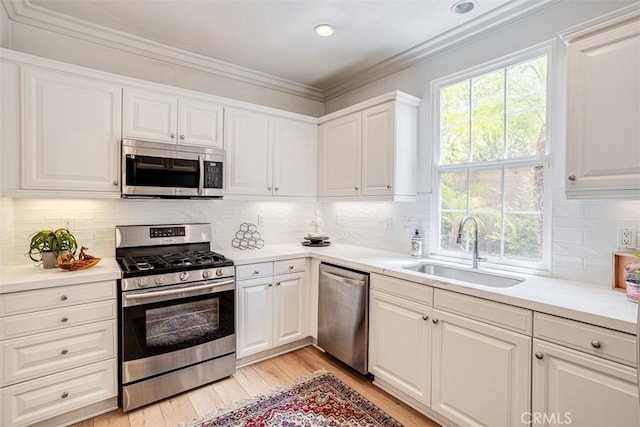 86 Canyoncrest, Irvine, CA 92603 - kitchen featuring stainless steel appliances, a sink, plenty of natural light, light wood-type flooring, and crown molding