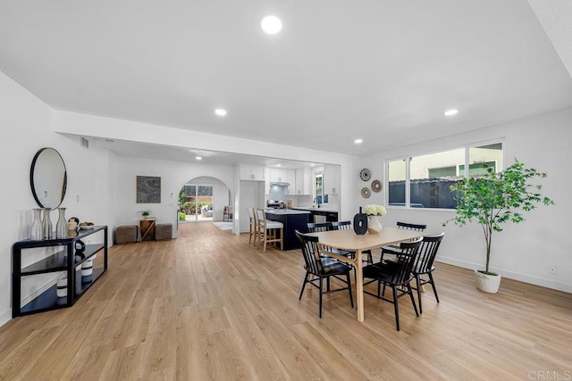 8184 Flanders Dr, San Diego, CA 92126 - dining space with arched walkways, light wood finished floors, baseboards, and recessed lighting