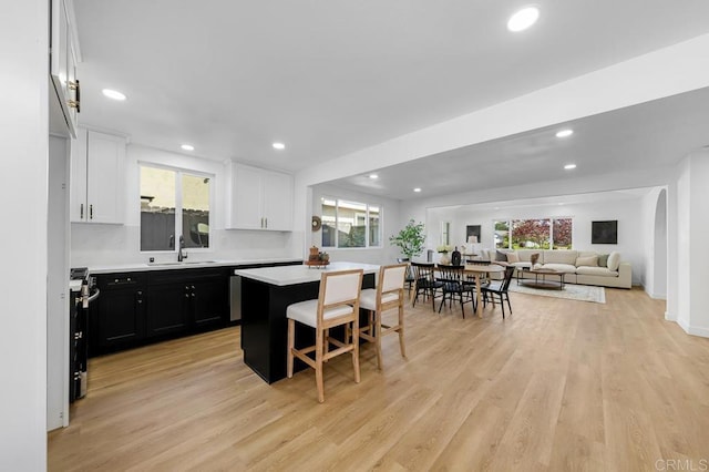 8184 Flanders Dr, San Diego, CA 92126 - kitchen featuring a sink, dark cabinets, light wood finished floors, a center island, and recessed lighting