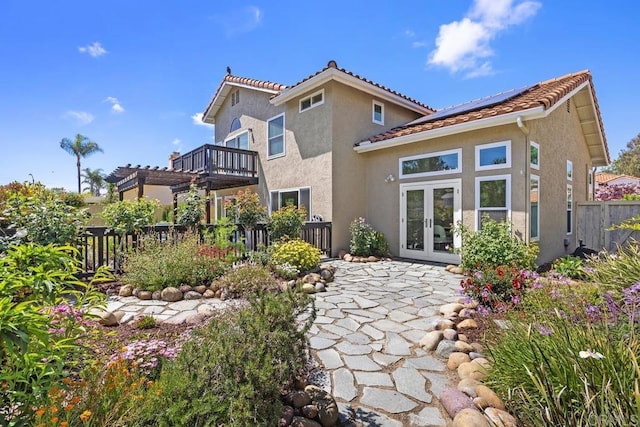 1707 Willowhaven Rd, Encinitas, CA 92024 - rear view of property featuring french doors, stucco siding, fence, solar panels, and a tile roof
