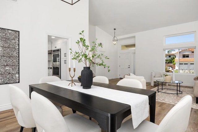 1707 Willowhaven Rd, Encinitas, CA 92024 - dining space featuring high vaulted ceiling, wood finished floors, and baseboards