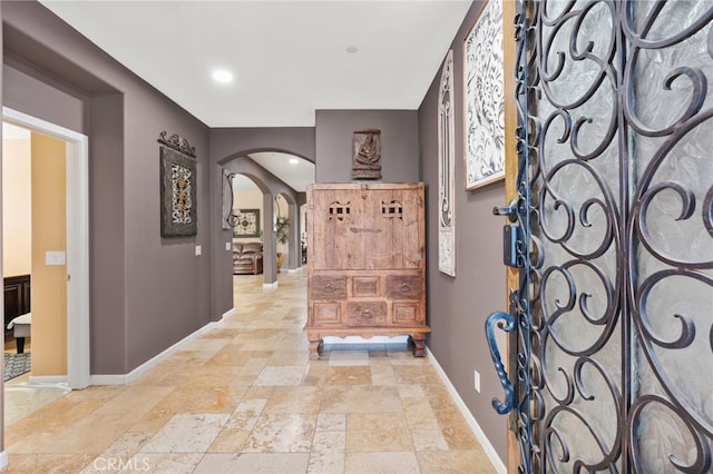 5801 S Moonstone Peak Dr, Bakersfield, CA 93313 - foyer with arched walkways, stone tile flooring, and baseboards