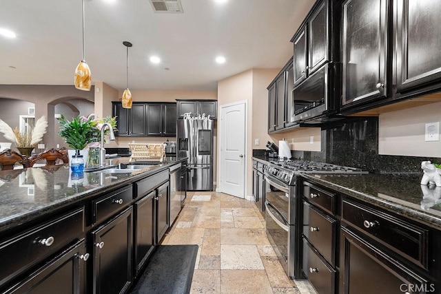 5801 S Moonstone Peak Dr, Bakersfield, CA 93313 - kitchen featuring stainless steel appliances, a sink, stone tile flooring, dark stone counters, and recessed lighting