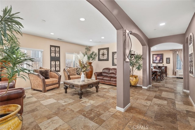 5801 S Moonstone Peak Dr, Bakersfield, CA 93313 - living room featuring arched walkways, stone tile floors, recessed lighting, and baseboards