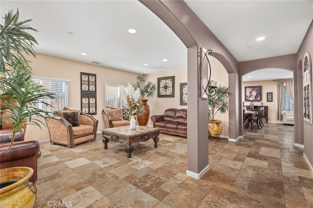 5801 S Moonstone Peak Dr, Bakersfield, CA 93313 - living room featuring arched walkways, stone tile floors, and recessed lighting