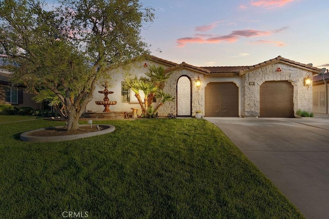 5801 S Moonstone Peak Dr, Bakersfield, CA 93313 - mediterranean / spanish home with an attached garage, concrete driveway, a front yard, and a tiled roof