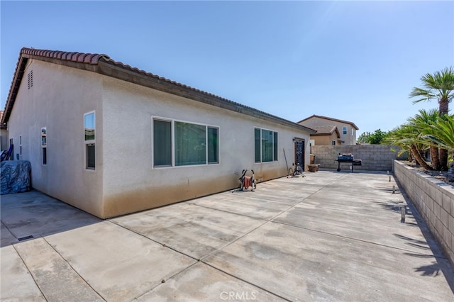 5801 S Moonstone Peak Dr, Bakersfield, CA 93313 - back of property with stucco siding, a patio area, a fenced backyard, and a tile roof