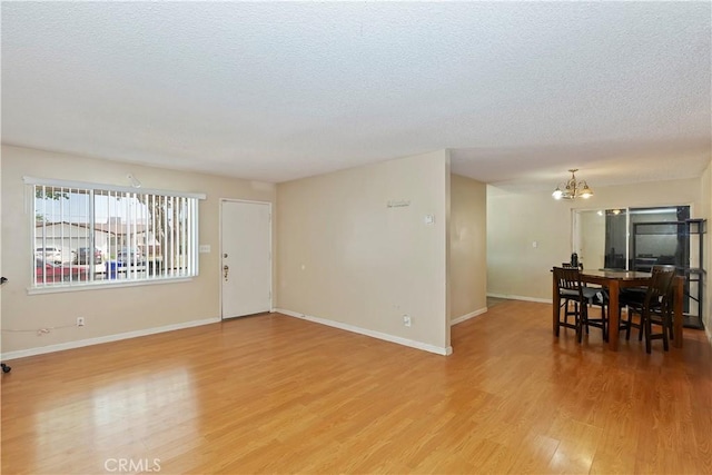 16193 Colina St, Victorville, CA 92395 - living area with light wood-type flooring, a chandelier, a textured ceiling, and baseboards