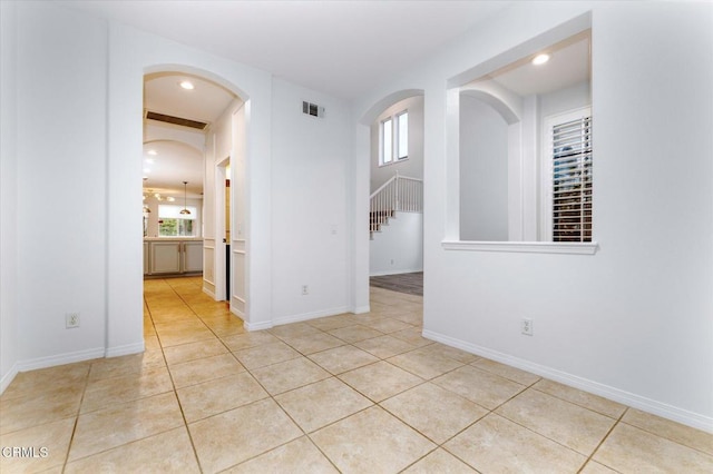 23839 Rio Ranch Way, Valencia, CA 91354 - spare room with arched walkways, healthy amount of natural light, light tile patterned floors, stairway, and recessed lighting