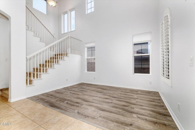 23839 Rio Ranch Way, Valencia, CA 91354 - unfurnished living room with a high ceiling, stairway, wood finished floors, and baseboards