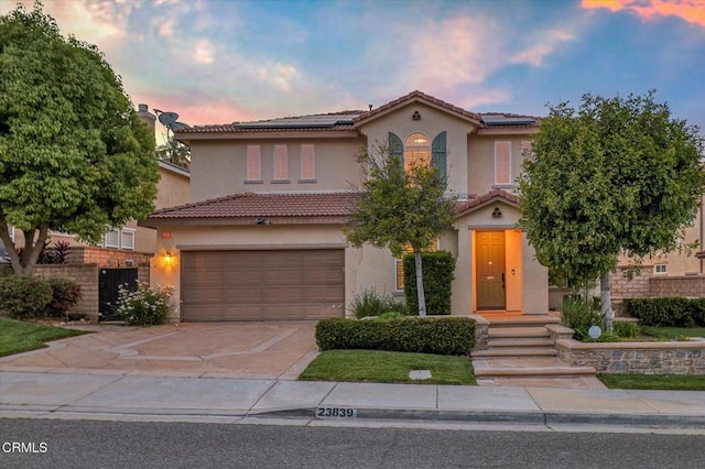 23839 Rio Ranch Way, Valencia, CA 91354 - mediterranean / spanish house with an attached garage, stucco siding, driveway, and roof mounted solar panels