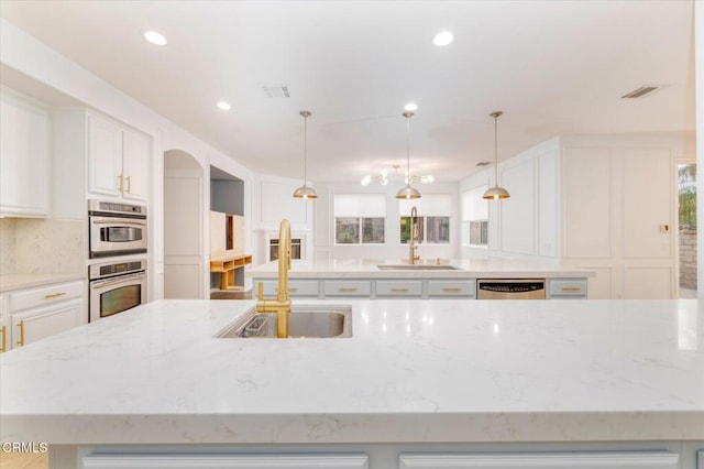 23839 Rio Ranch Way, Valencia, CA 91354 - kitchen featuring a large island with sink, a sink, stainless steel appliances, white cabinets, and recessed lighting