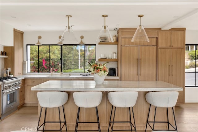 4335 Chaumont Rd, Woodland Hills, CA 91364 - kitchen featuring high end stainless steel range oven, a sink, open shelves, light wood-style floors, and a kitchen island