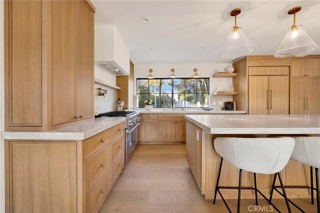 4335 Chaumont Rd, Woodland Hills, CA 91364 - kitchen featuring high end range, open shelves, light wood-type flooring, a kitchen bar, and a sink