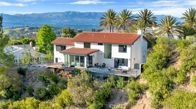 4335 Chaumont Rd, Woodland Hills, CA 91364 - rear view of house featuring a tiled roof, a chimney, a deck with mountain view, stucco siding, and central air condition unit